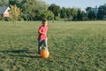 Little preschool Caucasian boy playing soccer football on playground outside. Kid kicking hitting ball. Happy authentic candid Royalty Free Stock Photo