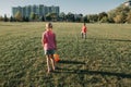 Little preschool girl and boy friends playing soccer football on playground grass field outside. Happy authentic candid childhood Royalty Free Stock Photo