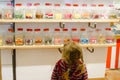 Little preschool girl in candy shop. Cute happy toddler child buy different bonbons and lollipop in a store. Royalty Free Stock Photo