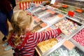 Little preschool girl in candy shop. Cute happy toddler child buy different bonbons and lollipop in a store. Royalty Free Stock Photo