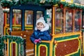 Little preschool girl on a carousel train at Christmas funfair or market, outdoors. Happy child having fun. Traditional Royalty Free Stock Photo