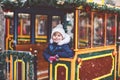 Little preschool girl on a carousel train at Christmas funfair or market, outdoors. Happy child having fun. Traditional Royalty Free Stock Photo