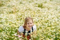 Little preschool girl in daisy flower field. Cute happy child in red riding hood dress play outdoor on blossom flowering Royalty Free Stock Photo