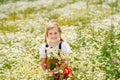 Little preschool girl in daisy flower field. Cute happy child in red riding hood dress play outdoor on blossom flowering Royalty Free Stock Photo