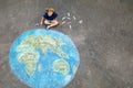 Little preschool girl with earth globe painting with colorful chalks on ground. Positive toddler child. Happy earth day Royalty Free Stock Photo