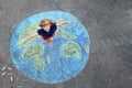 Little preschool girl with earth globe painting with colorful chalks on ground. Positive toddler child. Happy earth day Royalty Free Stock Photo