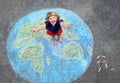 Little preschool girl with earth globe painting with colorful chalks on ground. Positive toddler child. Happy earth day Royalty Free Stock Photo