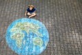 Little preschool girl with earth globe painting with colorful chalks on ground. Positive toddler child. Happy earth day Royalty Free Stock Photo