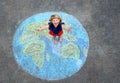 Little preschool girl with earth globe painting with colorful chalks on ground. Positive toddler child. Happy earth day Royalty Free Stock Photo