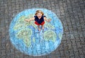 Little preschool girl with earth globe painting with colorful chalks on ground. Positive toddler child. Happy earth day Royalty Free Stock Photo