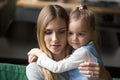 Little preschool girl embracing tired, upset mother