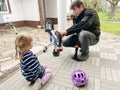 Little preschool girl and father repair chain on bike and inflate tires of bicycle. Child and dad work together. Family