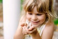 Little preschool girl holding small wild frog. Happy curious child watching and exploring animals in nature. Royalty Free Stock Photo