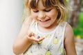 Little preschool girl holding small wild frog. Happy curious child watching and exploring animals in nature. Royalty Free Stock Photo