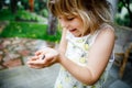 Little preschool girl holding small wild frog. Happy curious child watching and exploring animals in nature. Royalty Free Stock Photo