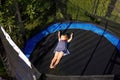 Little preschool girl jumping on trampoline. Happy funny toddler child having fun with outdoor activity in summer Royalty Free Stock Photo