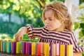 Little preschool girl playing board game with colorful bricks domino. Happy child build tower of wooden blocks Royalty Free Stock Photo