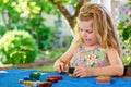 Little preschool girl playing board game with colorful bricks. Happy child build tower of wooden blocks, developing fine Royalty Free Stock Photo