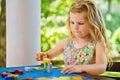 Little preschool girl playing board game with colorful bricks. Happy child build tower of wooden blocks, developing fine Royalty Free Stock Photo