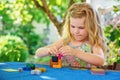 Little preschool girl playing board game with colorful bricks. Happy child build tower of wooden blocks, developing fine