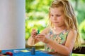 Little preschool girl playing board game with colorful bricks. Happy child build tower of wooden blocks, developing fine