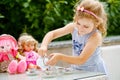 Little preschool girl playing with dolls. Happy excited child play tea party with toys. Role games for children Royalty Free Stock Photo