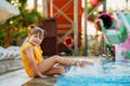 Little preschool girl playing in outdoor swimming pool by sunset. Child learning to swim in outdoor pool, splashing with Royalty Free Stock Photo