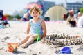 Little preschool girl playing with sand toys on the beach. Cute happy toddler child on family vacations on the sea Royalty Free Stock Photo