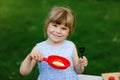 Little preschool girl playing with toy kitchen in garden. Happy toddler child having fun with role activity game Royalty Free Stock Photo