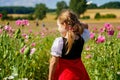 Little preschool girl in poppy field. Cute happy child in red riding hood dress play outdoor on blossom flowering meadow Royalty Free Stock Photo