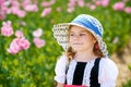 Little preschool girl in poppy field. Cute happy child in red riding hood dress play outdoor on blossom flowering meadow Royalty Free Stock Photo