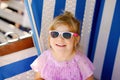 Little preschool girl resting on beach chair. Cute happy toddler child on family vacations on the sea. Kid playing Royalty Free Stock Photo