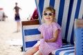 Little preschool girl resting on beach chair. Cute happy toddler child on family vacations on the sea. Kid playing Royalty Free Stock Photo