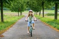 Little preschool girl riding bike. Kid on bicycle outdoors. Happy child enjoying bike ride on her way to school on warm summer day Royalty Free Stock Photo