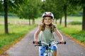 Little preschool girl riding bike. Kid on bicycle outdoors. Happy child enjoying bike ride on her way to school on warm summer day Royalty Free Stock Photo