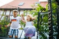 Little preschool girl and school kid boy jumping on trampoline. Happy funny siblings children having fun with outdoor Royalty Free Stock Photo