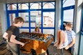 Little preschool girl and two kids school boys playing table soccer. Happy excited positive children having fun with Royalty Free Stock Photo
