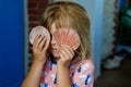 Little preschool girl with variation of different shells and clams at home. Happy child with collected shell from