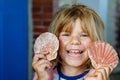 Little preschool girl with variation of different shells and clams at home. Happy child with collected shell from