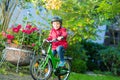 Little preschool kid boy in helmet biking on bicycle in the autu