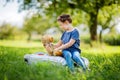 Little preschool kid girl driving big vintage old toy car and having fun with playing with big plush toy bear, outdoors Royalty Free Stock Photo
