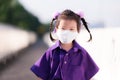 Little preschool student with a new normal lifestyle. Girl wearing white cloth mask was walking to school in the morning.