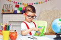 A little preschooler boy counts on the abacus in a math lesson.