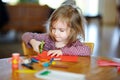 Little preschooler girl cutting paper