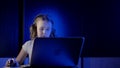 Little preschooler girl is sitting alone in front of notebook in night in home, using computer mouse Royalty Free Stock Photo