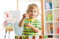 Little preschooler kid boy playing with toy cubes and memorizing letters. Early education and preschool concept