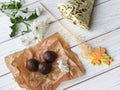 A little present, fresh flowers and some chocolate candies on a white wooden surface