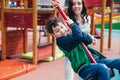 Little pretty boy is having fun outdoor. Playing in children zone in amusement park.