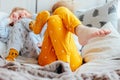 Little pretty brother and sister in pajamas lying in bed, cozy morning, focus on legs Royalty Free Stock Photo