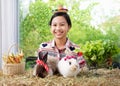 little pretty farmer girl in wear a little cute hat smiling with two rabbits and vegetables in a basket and a shopping cart selec Royalty Free Stock Photo